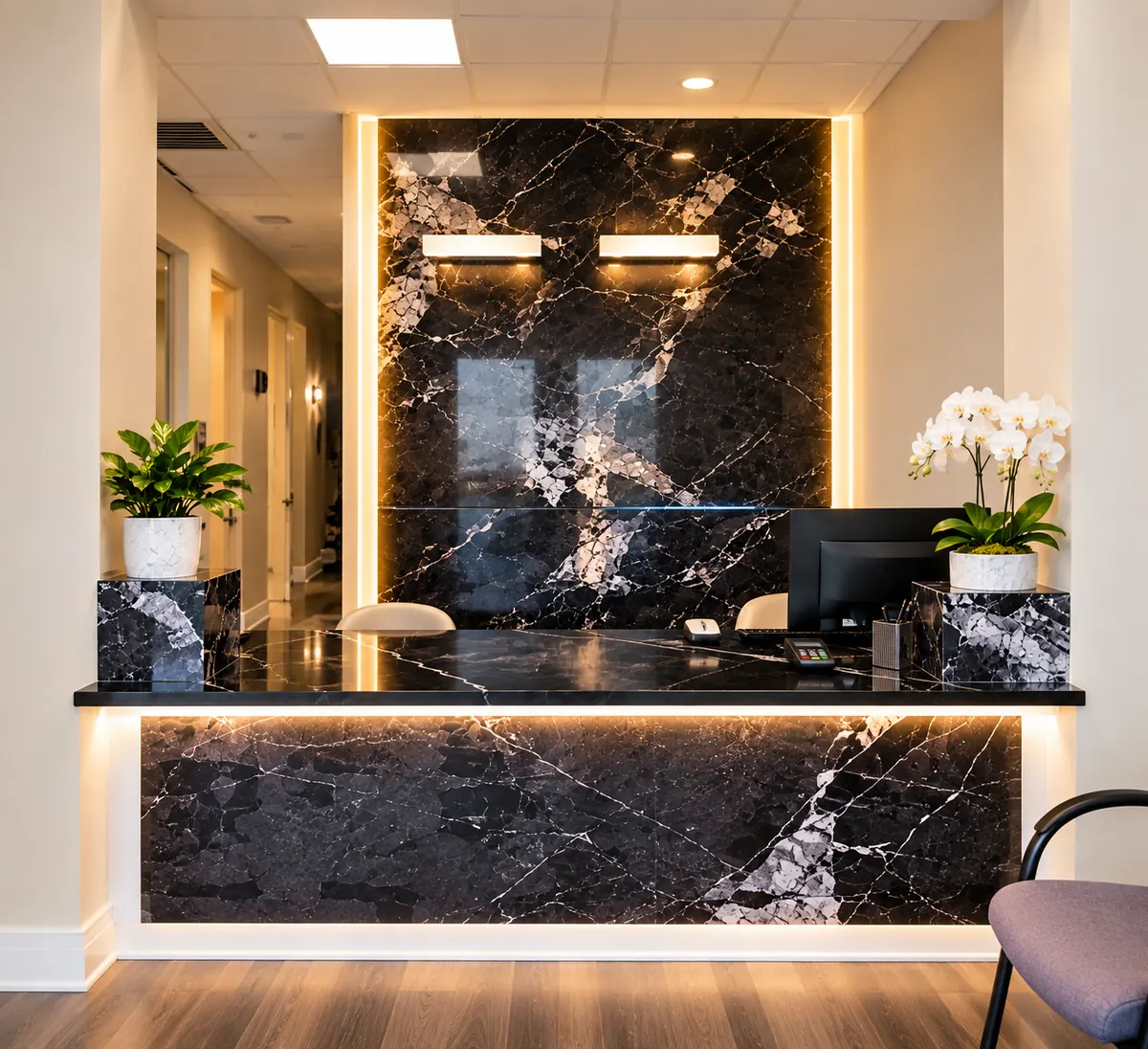 Front reception desk with a black marble counter and white orchids
